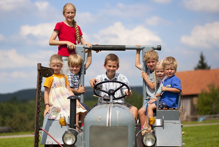 Germany, Bavaria, Group of children sitting in old tractor