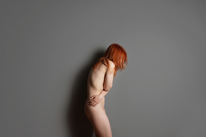 body shaming or sexual harassment or abuse concept with unrecognizable naked woman hiding body and face, by Axel Bueckert