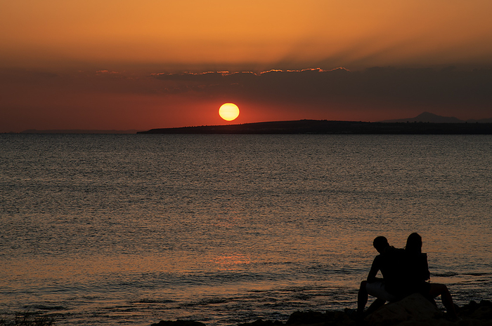 Silhouette of young couple enjoying beautiful sunset at the beach. Romantic moment human relationship Silhouette of young couple enjoying beautiful sunset at the beach. Romantic moment human relationships