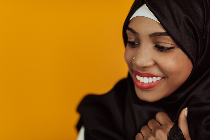 Muslim woman with a beautiful smile wearing a hijab poses in the studio Muslim woman with a beautiful smile wearing a hijab poses in the studio. High quality photo
