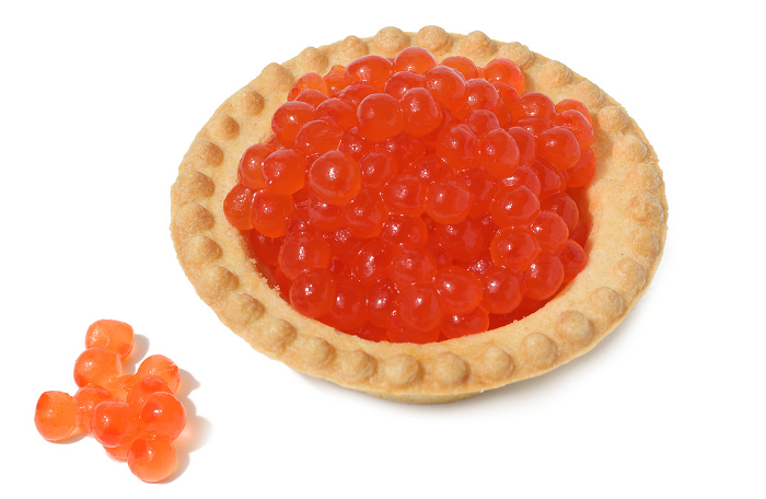 Red caviar in a round tartlet on a white isolated background, delicious snack Red caviar in a round tartlet on a white isolated background, delicious snack