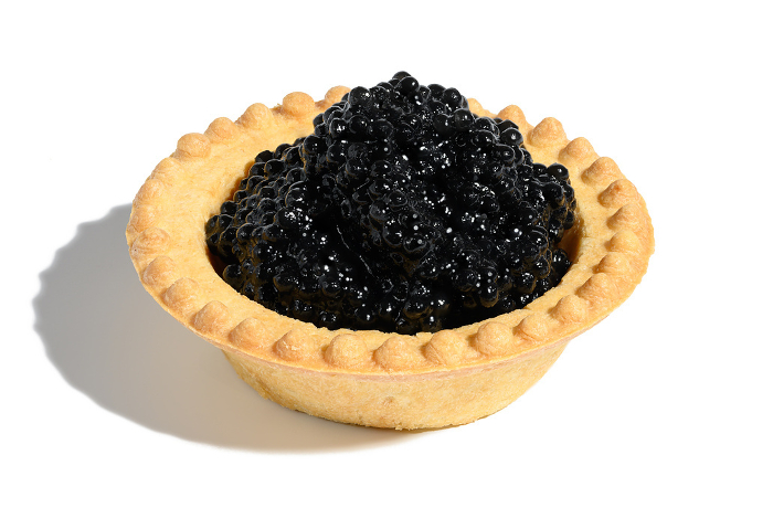 Black caviar in a round tartlet on a white isolated background Black caviar in a round tartlet on a white isolated background