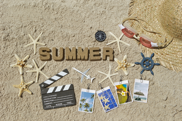 Summer alphabet letters and summer accessories placed on sandy beach Summer image