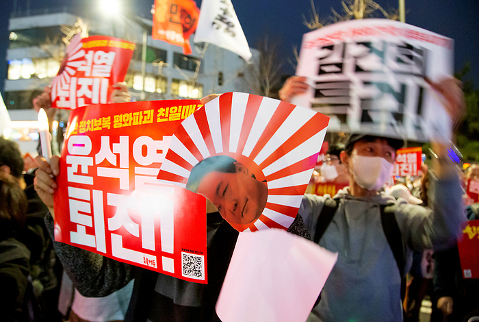 Anti Japan and anti Yoon Suk Yeol candlelight vigil in Seoul Anti Yoon Suk Yeol and anti Japan rally, Mar 11, 2023 : Holding a mock rising sun flag of Japan disgraced with a portrait of South Korean President Yoon Suk Yeol, a man attends protest marches in front of the Japanese Embassy in Korea during a candlelight vigil in Seoul, South Korea. Thousands of people demanded President Yoon Suk Yeol resign as they denounced his government s proposed plan to compensate South Korean victims of Japan s wartime forced labor through a Seoul backed public foundation, instead of direct payment from responsible Japanese firms. The plan was announced by South Korean Foreign Minister on March 6 to resolve the issue of compensating Korean victims who won legal battles against two Japanese firms accused of mobilizing them for hard labour during World War II, when Korea was under Japan s colonization. Signs read,  Yoon Suk Yeol resign    L  and  Organize a special prosecution to investigate Kim Keon Hee  wife of President Yoon, who manipulated stock price     R .  Photo by Lee Jae Won AFLO   SOUTH KOREA 