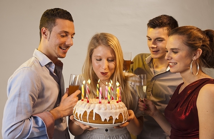 Group of young people celebrating with birthday cake