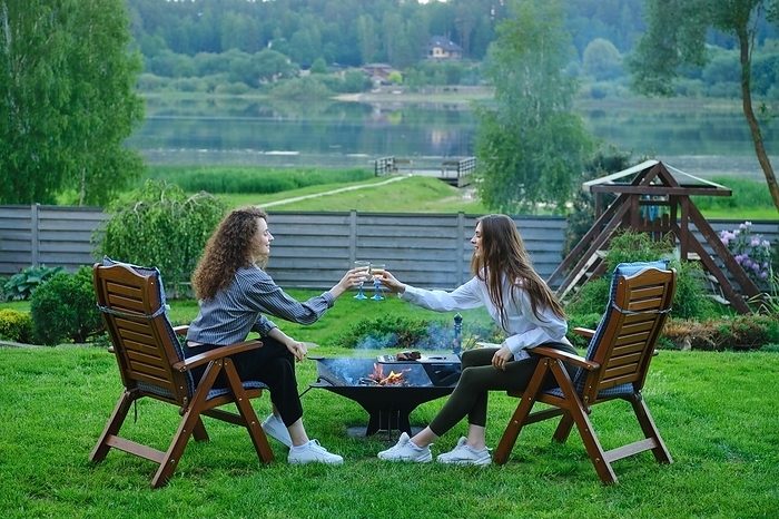 Happy women toasting white wine outdoors