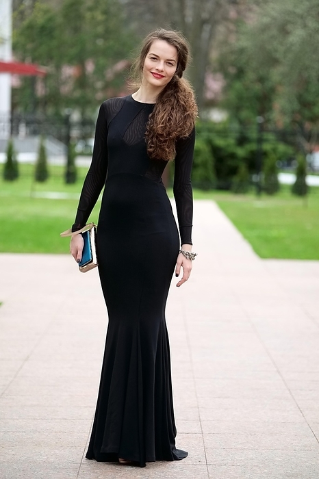 Gorgeous lady in black fitted dress approaching the alley