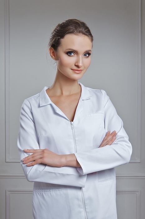 Beautiful female doctor in white clothes. Portrait of attractive medic in white robe