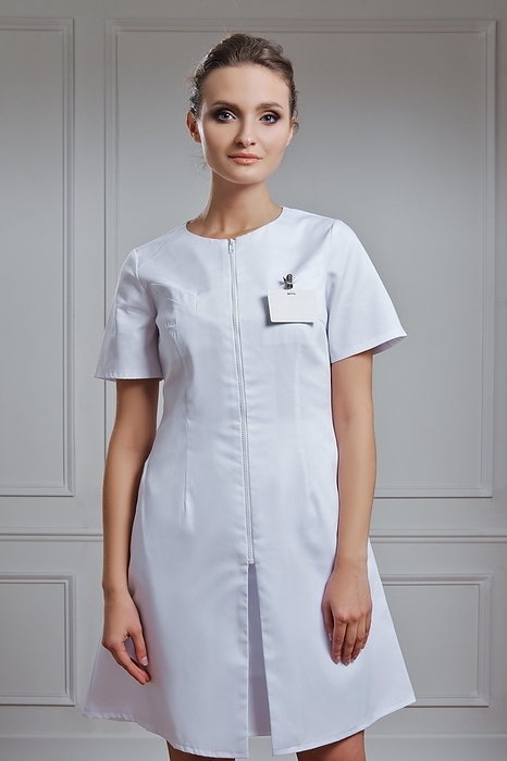 Beautiful female doctor in white uniform. Portrait of attractive medic in white robe