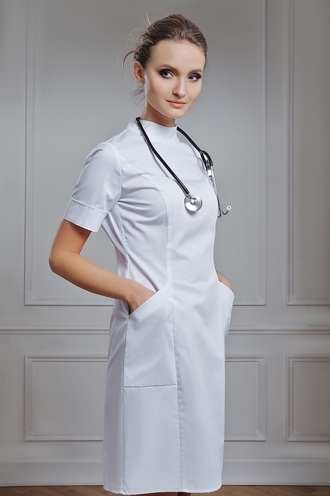 Beautiful female doctor in white uniform. Portrait of attractive medic in white robe