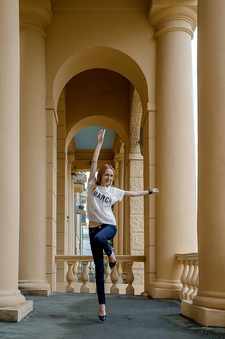 Soft focus photo of jumping pretty young girl between columns