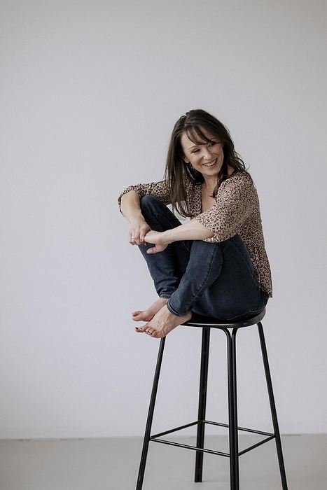 Woman, 40+, sitting on stool