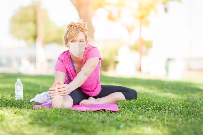 Girl wearing medical face mask during workout outdoors