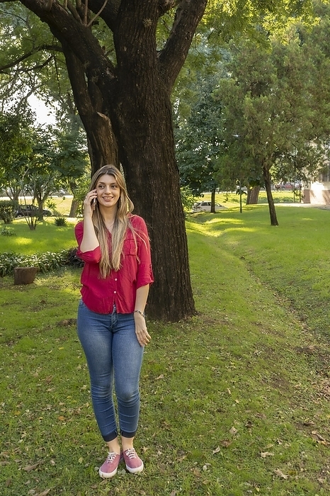 Young blonde woman talking on the phone in the park