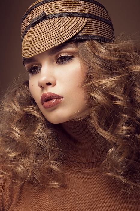 Pretty fresh girl, image of modern Twiggy in fashionable brown hat, with unusual eyelashes and curls. Photos shot in studio