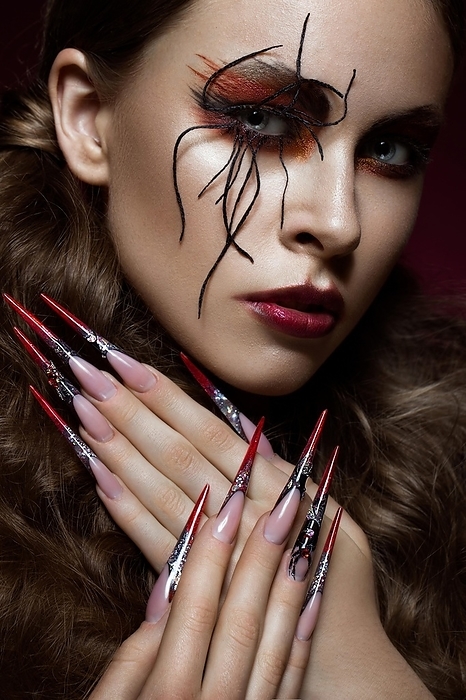 Portrait of woman in the image of spider with creative art makeup and long nails. Manicure design, beauty face. Photos shot in studio