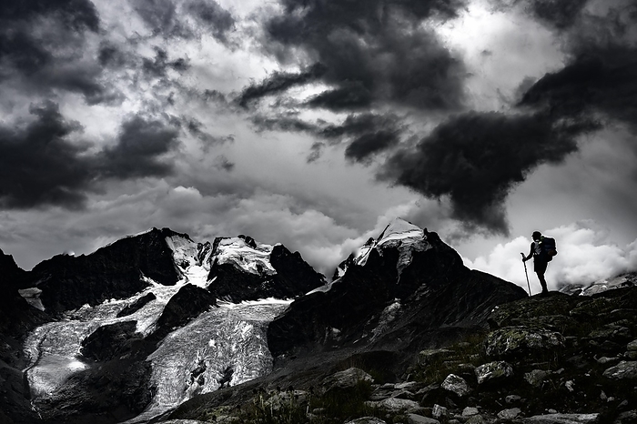 Climbers in front of the summit of Bernina Group with dramatic clouds, St Moritz, Engadin, Graub眉nden, Switzerland, Europe