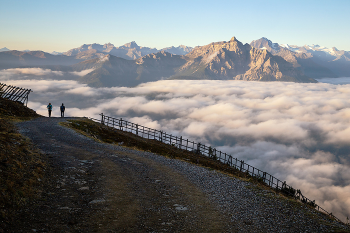 Austria A couple of hikers descending Patscherkofel mountain on a foggy morning, Innsbruck Land, Tyrol, Austria, Europe. Photo by: Emanuele Vidal