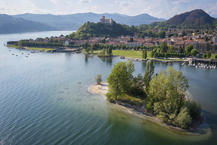 Italy View of the town of Angera and its fortress called Rocca di Angera on a spring day with the small island called Isolino Partegora. Angera, Lake Maggiore, Varese district, Lombardy, Italy.. Photo by: Mirko Costantini