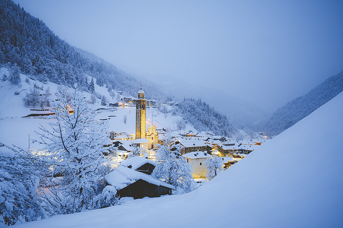 Italy Winter dusk over mountains and village covered with snow, Gerola Alta, Valgerola, Orobie Alps, Valtellina, Lombardy, Italy. Photo by: Roberto Moiola