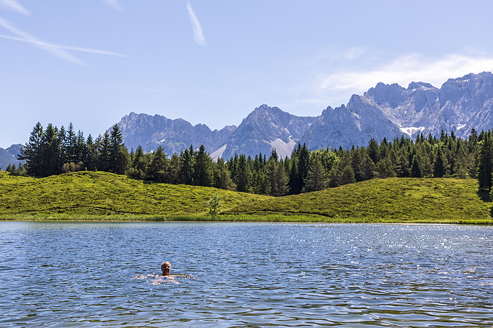 Germany, Bavaria, man swimming in Wildensee lake