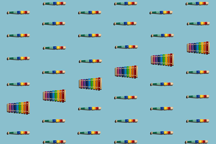 Pattern of colorful flutes and xylophones flat laid against blue background