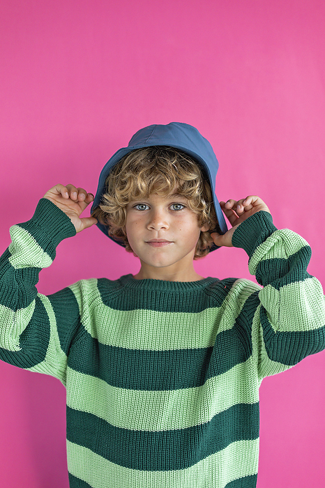 Boy wearing bucket hat against pink background