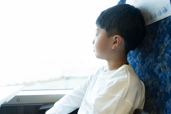 Elementary school boy looking out of train window