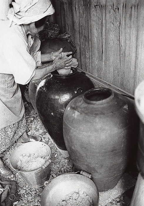 Nari miso making in Ryugo Town, Amami Oshima Island, Japan  Date of photograph unknown  Making nari miso in Tatsugo Town, Amami Oshima Island, Japan The finished nari miso is stored in jars.