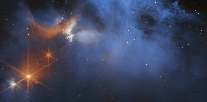 Chamaeleon I molecular cloud, JWST image Central region of the Chamaeleon I dark molecular cloud. Cloud material  blue, centre  is illuminated by the young, outflowing protostar Ced 110 IRS 4  orange, upper left . Background stars behind the cloud are seen as orange dots. Different ices in the clouds absorb this starlight as it passes through them. Chamaeleon I is 630 light years from Earth. Image captured by the Near Infrared Camera  NIRCam ., by NASA,ESA,CSA and M. Zamani  ESA Webb  SCIENCE PHOTO LIBRARY