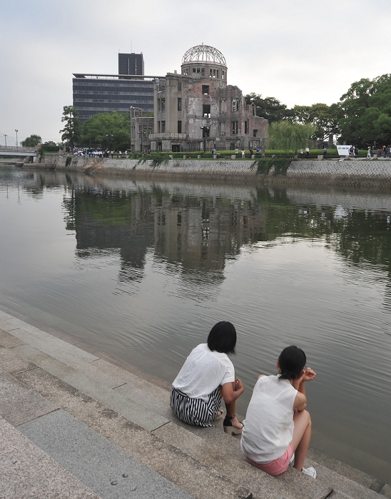 68 years after the atomic bombing of Hiroshima Peace Memorial Ceremony  Hiroshima, Japan, August 6, 2013 : Girls sit near Motoyasu River in front of the Atomic Bomb Dome on marking the 68th anniversary of the atomic bombing in Hiroshima, Japan, on August 6, 2013.  Photo by AFLO 