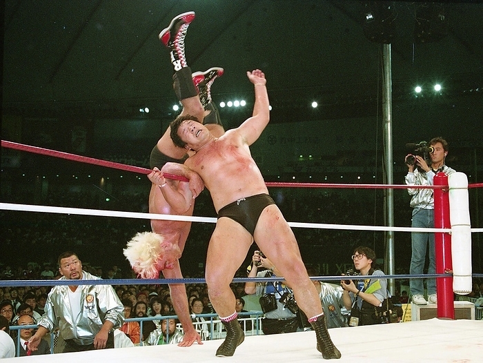 1991 New Japan Pro Wrestling Tokyo Dome, NBA   IGGP Heavyweight W Title Match 19910321, New Japan Pro Wrestling, Tatsumi Fujinami throws Ric Flair  left  out of the ring with a shoulder through for the NWA World and IWGP Heavyweight W title match at Tokyo Dome.