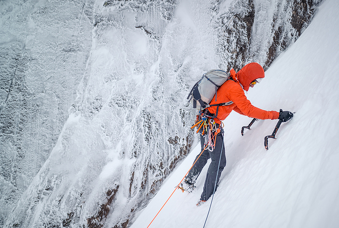 Male mountaineer ice climbing in snowy and frosty conditions Male mountaineer ice climbing in snowy and frosty conditions