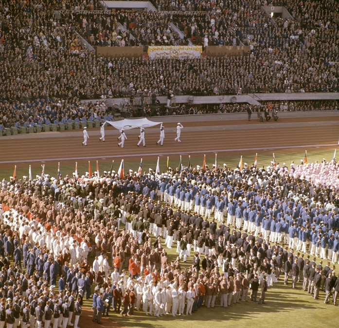 1964 Tokyo Olympics Opening Ceremony General view, OCTOBER 10, 1964   Opening ceremony : Tokyo Olympics. Opening ceremony. On October 10, 1964, the opening ceremony of the Tokyo Olympics was held at the National Stadium in Tokyo under a  sunny Olympics  sky. After the Emperor Showa s opening proclamation, eight members of the Maritime Self Defense Force dressed in white sailor suits entered from the south gate of the stadium, holding up the Olympic flag. The Olympic flag moves forward as about 5,500 athletes from 94 countries look on.
