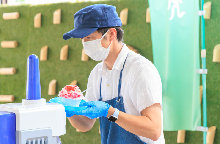 Man making shaved ice at a summer event.