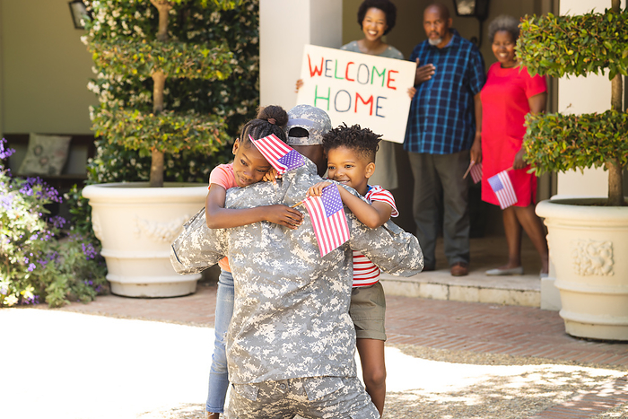 Happy african american soldier wearing military uniform greeting with his family. Military, returning home, patriotism and family.