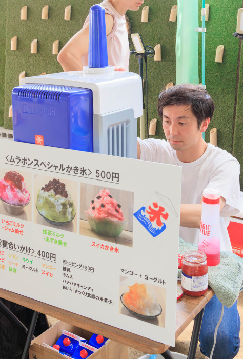 Man making shaved ice at a summer event.