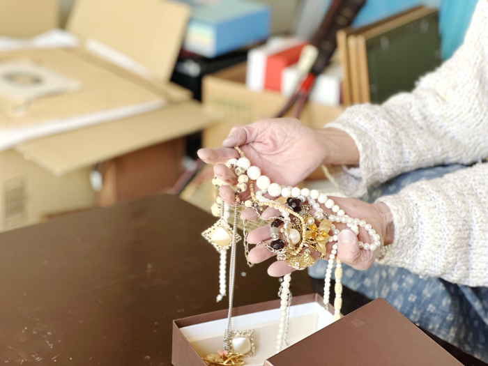 Elderly woman's hand taking jewelry out of box during decluttering