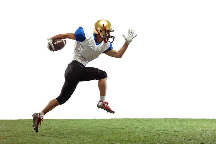 American football player in action isolated on white studio background In jump, flight. American football player isolated on white studio background with copyspace. Professional sportsman during game playing in action and motion. Concept of sport, movement, achievements.