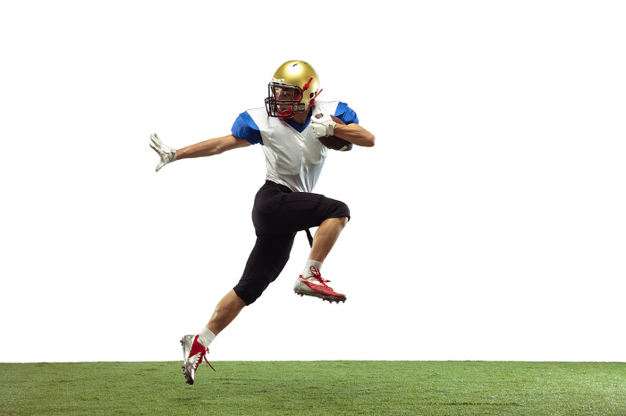 American football player in action isolated on white studio background In jump, flight. American football player isolated on white studio background with copyspace. Professional sportsman during game playing in action and motion. Concept of sport, movement, achievements.