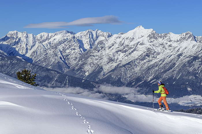 Austria, Tyrol, Female skier ascending snowcapped slope in Tux Alps
