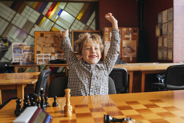 Happy boy playing at chess school