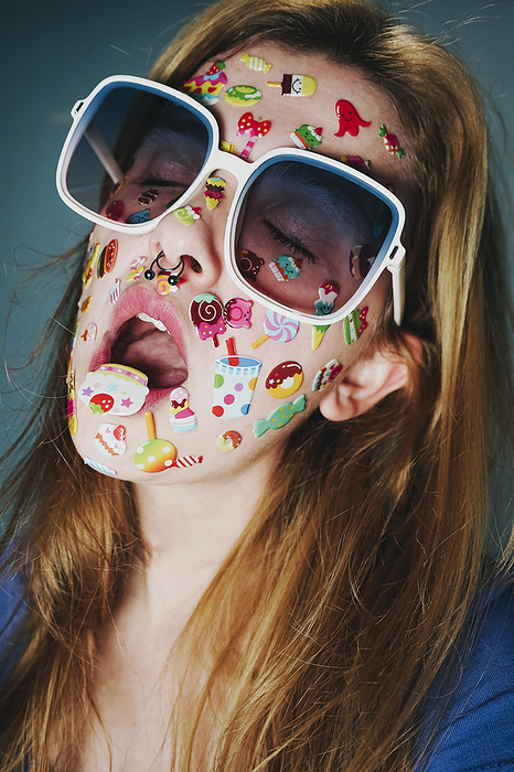 Woman with stickers on face wearing sunglasses