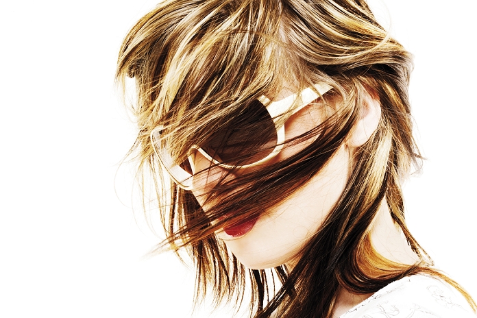 Young woman with sun glasses in the wind