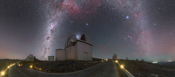 MPG ESO 2.2 metre telescope at night, Chile This panoramic photograph shows the Milky Way galaxy arching above ESO s La Silla Observatory in Chile. Milky Way arches above the open dome of the MPG ESO 2.2 metre telescope, which appears to be gobbling up the bright smudge of the Large Magellanic Cloud. Various clouds and nebulae, including the Gum Nebula, stand out against the dark sky in the central upper part of the image, shining in a range of pinkish hues., by ESO PETR HORALEK SCIENCE PHOTO LIBRARY