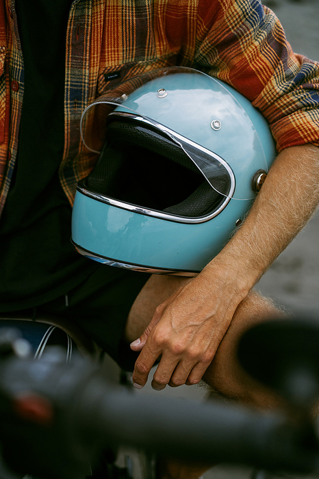 A man holds a motorcycle helmet in his hands.