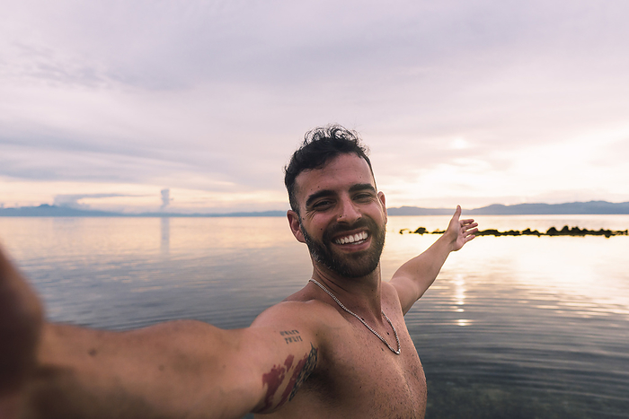 Happy man taking selfie at beach
