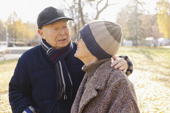 Senior man with arm around woman at autumn park