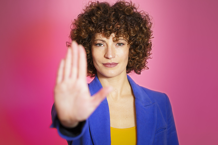 Woman stop gesturing against magenta background