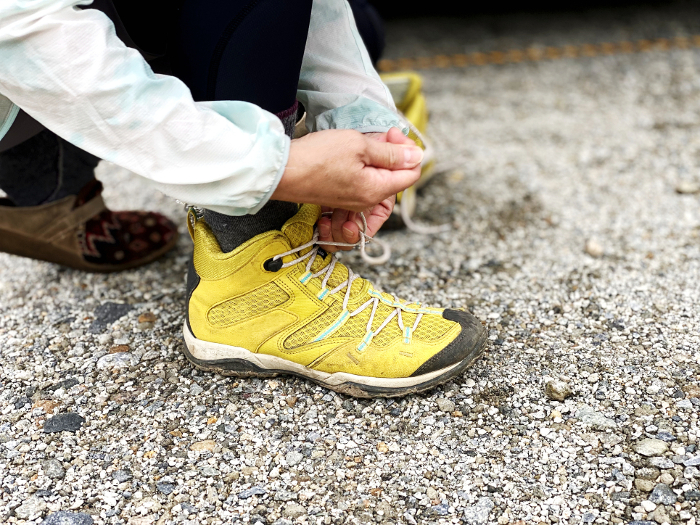 Hand tying shoelaces of yellow trekking shoes